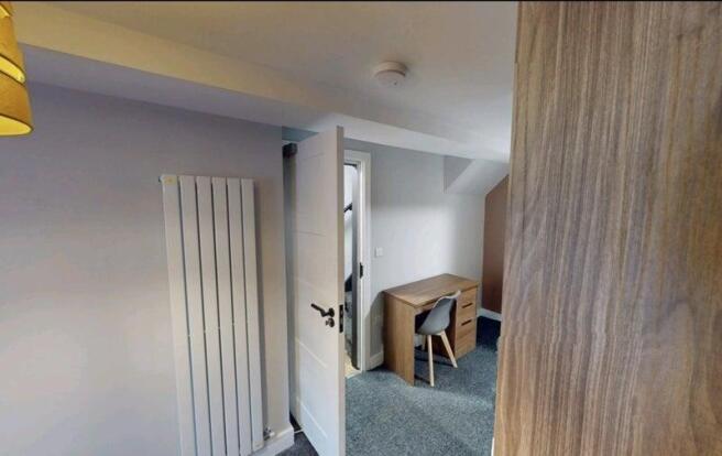 Bright, neatly furnished bedroom with neutral d...