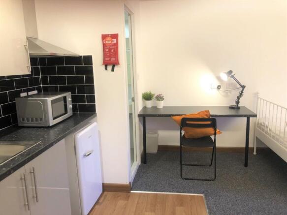 A neat and functional student room featuring a ...