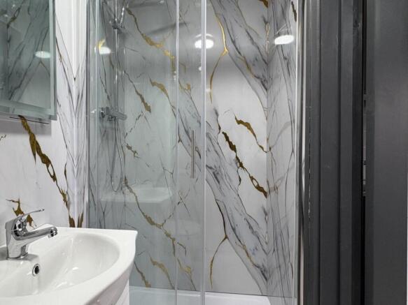 Modern bathroom with a glass-enclosed shower, s...
