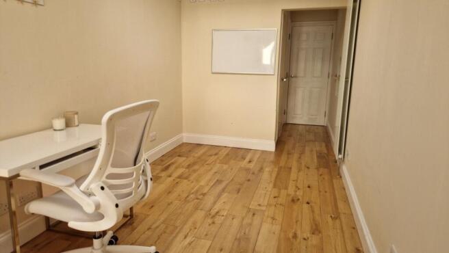 Bright study area with desk and wooden floor...