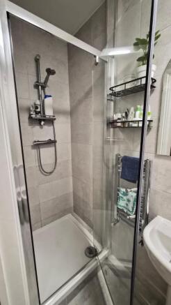Modern tiled bathroom with a glass shower enclo...