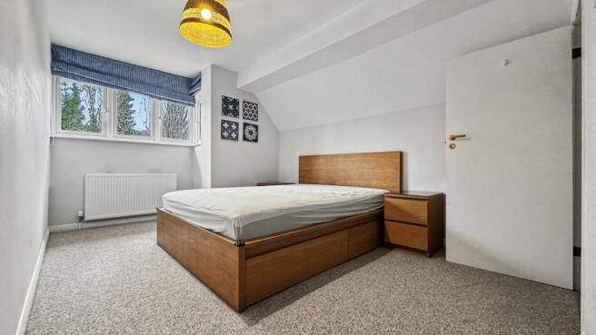Bright, simply styled double bedroom with a woo...