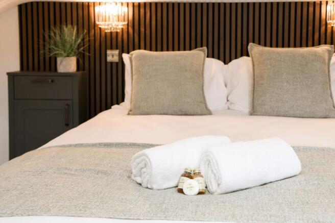 Stylish double bed with fresh towels and amenit...