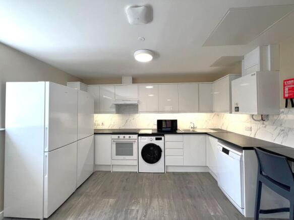 Bright, modern fitted kitchen with white gloss ...