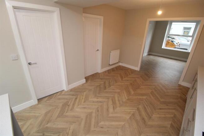 Bright hallway with stylish herringbone floorin...