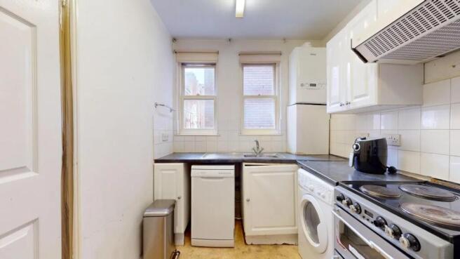 A compact kitchen featuring modern appliances i...