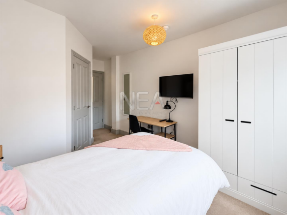 Polished estate bedroom with pink throw.png