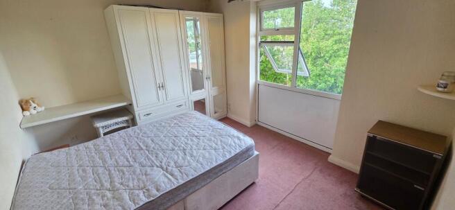 Bright bedroom with ample storage and leafy vie...