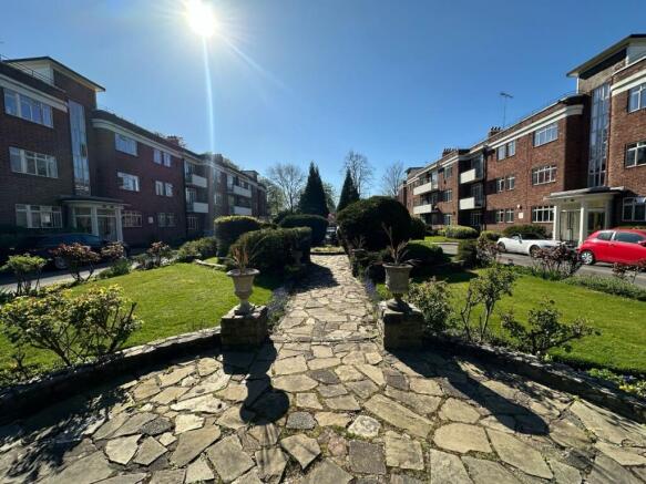 Lush manicured garden with sunlit stone path...