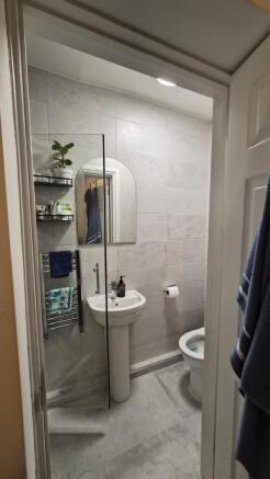 Modern tiled bathroom with a pedestal sink, wal...