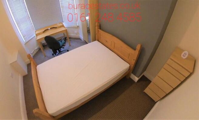 Bright, simply furnished bedroom with a double ...
