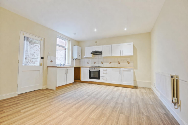 Modern kitchen-lounge with light wooden flooring.p