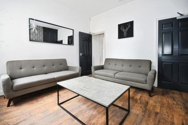 Bright, modern living room with two matching gr...