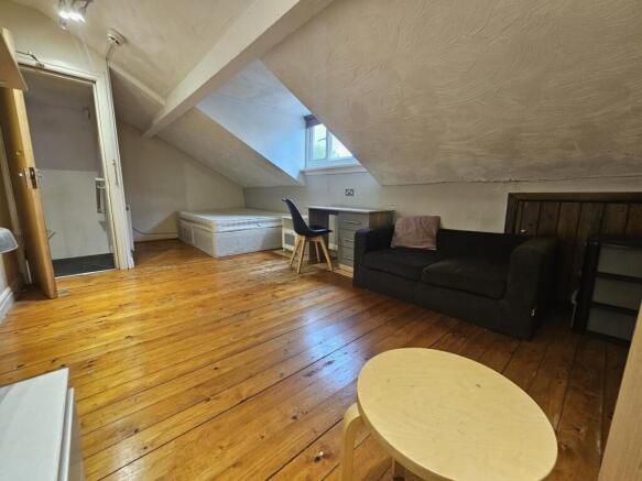 Bright attic-style living space with polished w...
