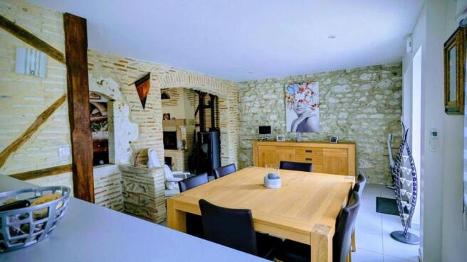Salle à manger avec murs en pierre apparente, gran