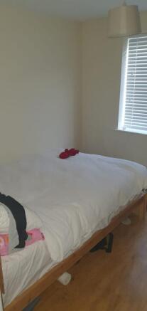 Bright, simply furnished bedroom with a comfort...