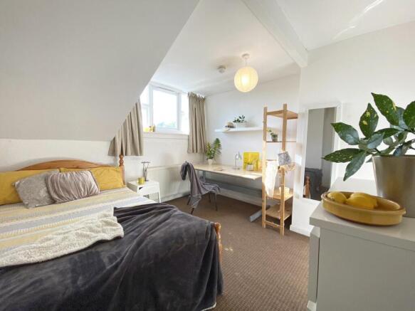 Bright, neatly styled double bedroom with a com...