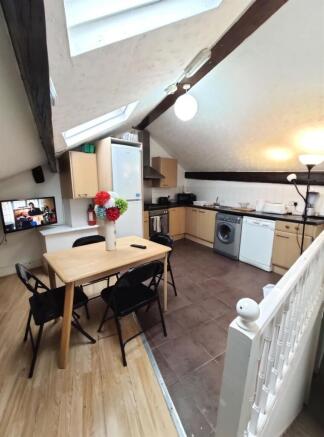 Bright open-plan kitchen with sloped ceilings a...