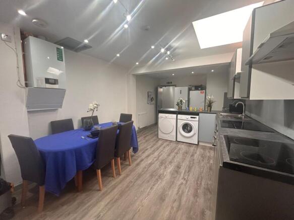 Modern shared kitchen with dining table and was...