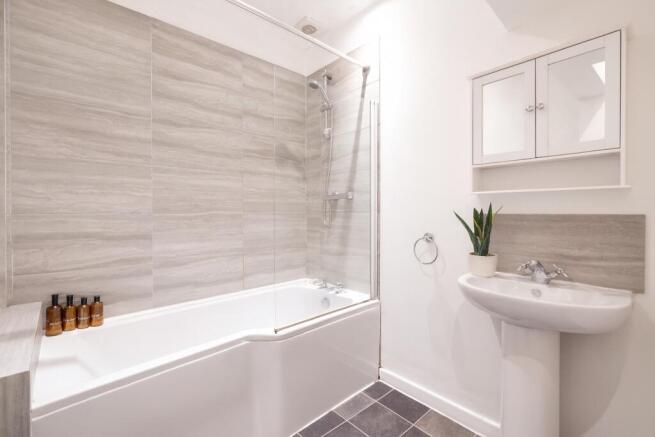 Bright, modern bathroom with a combined bath an...