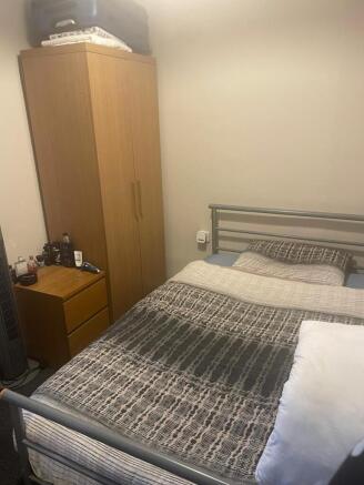Neat furnished bedroom with a double metal bed,...