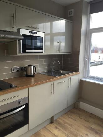 Modern kitchen with sleek gloss units and view...