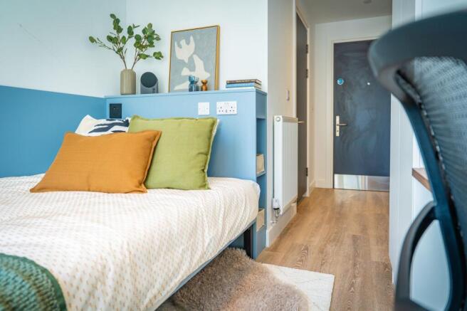 Bright modern bedroom with stylish blue headboa...