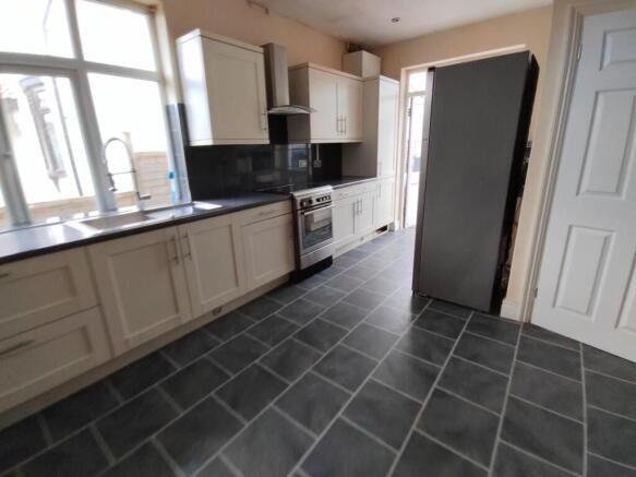 Bright kitchen with modern units and large wind...