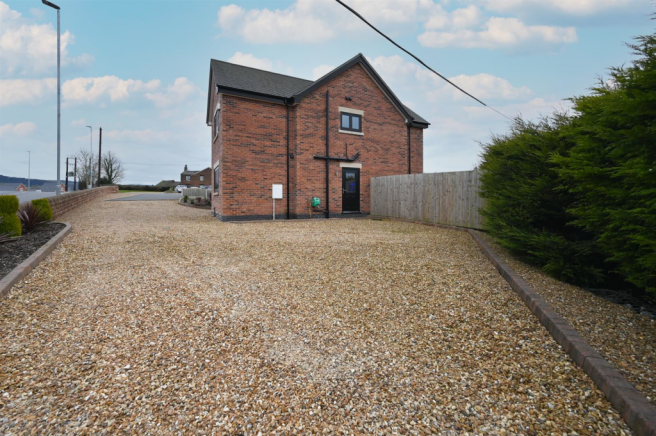 Golden gravel driveway to front and side