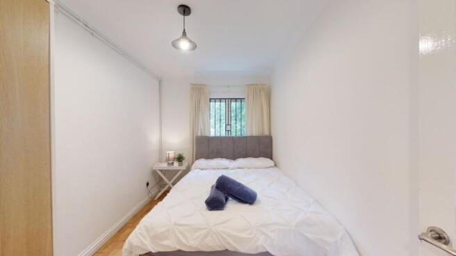 Bright, neatly presented bedroom with a comfort...