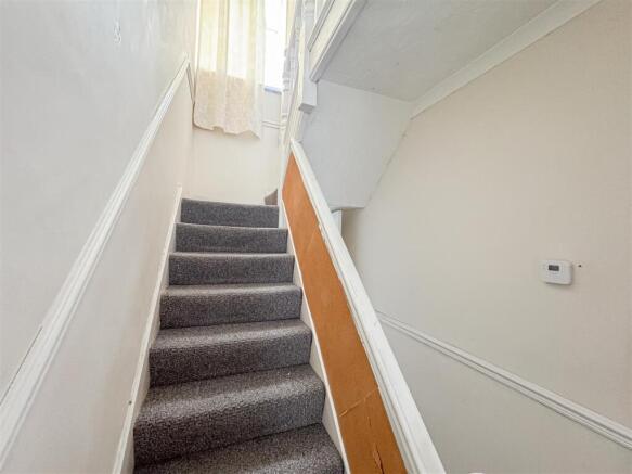 Bright and tidy carpeted staircase...
