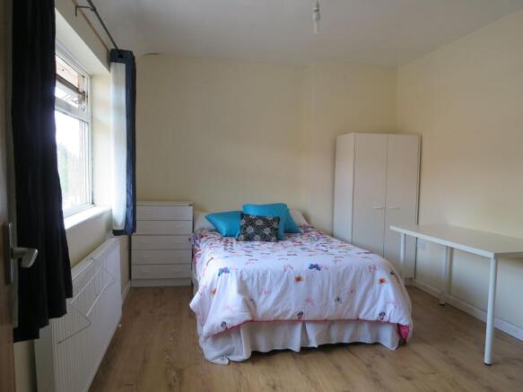 Bright, neat bedroom with a double bed dressed ...