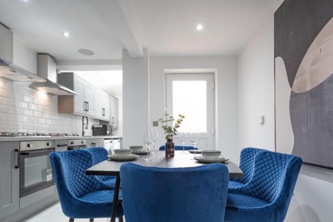 A modern and stylish kitchenette with a cozy di...