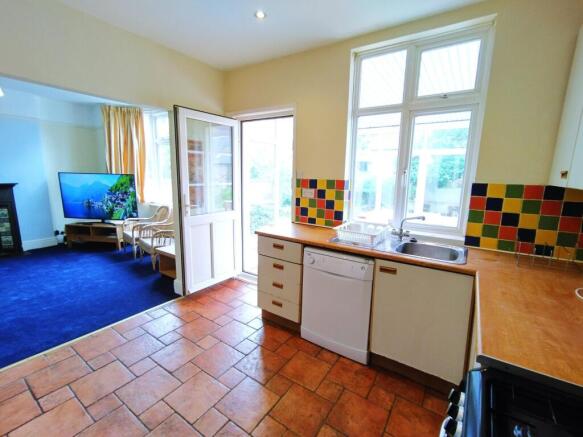 Bright kitchen with colourful tiled splashback,...