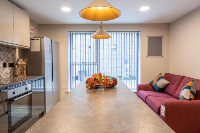 Modern kitchen island with sofa and pendant lig...