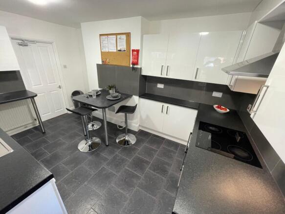 Modern fitted kitchen with glossy white cabinet...