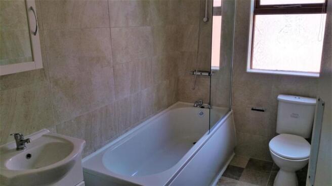 Bright, modern bathroom with a bathtub/shower c...