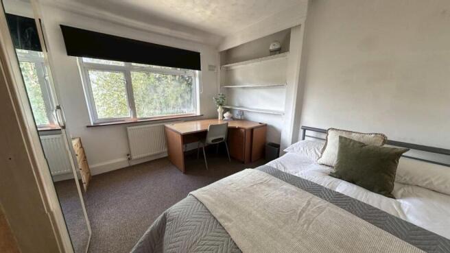 A cozy student bedroom featuring a neatly made ...