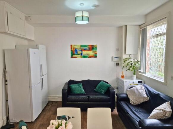 Bright, tidy lounge with two black leather sofa...