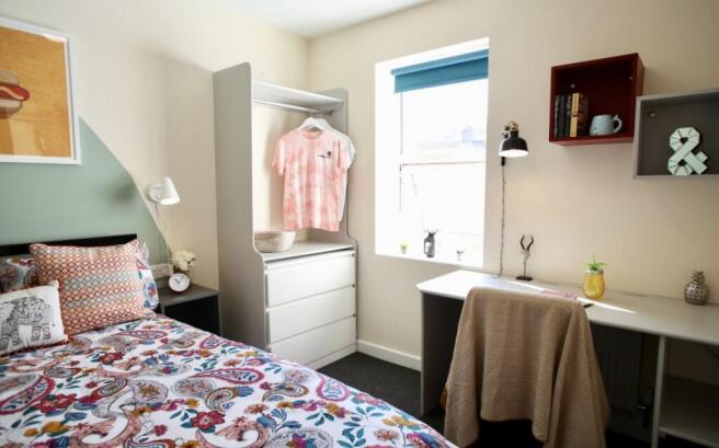 This cozy double bedroom features a vibrant dec...