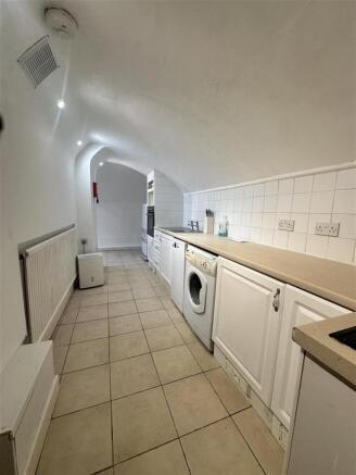 Galley kitchen with arched ceiling and applianc...