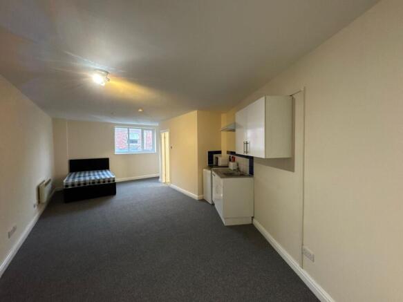 Spacious and bright living area with large wind...