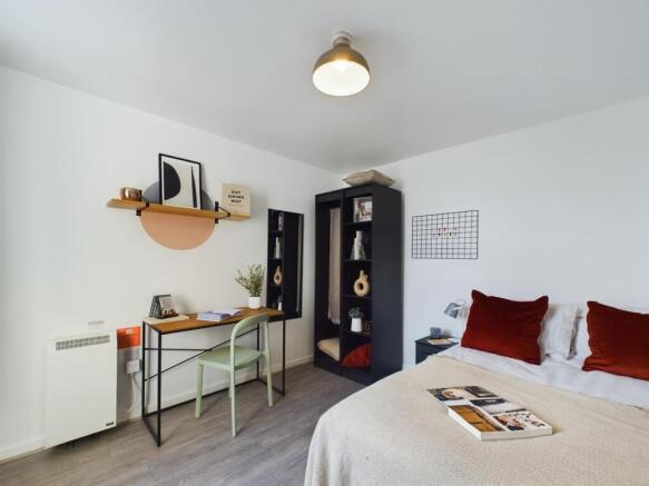 This inviting double bedroom features a cozy be...