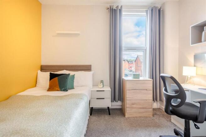 Bright bedroom with stylish yellow feature wall...