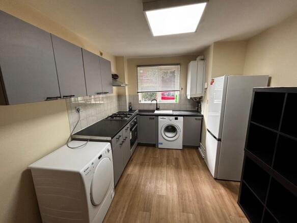 Modern kitchen with sleek grey units and laundr...