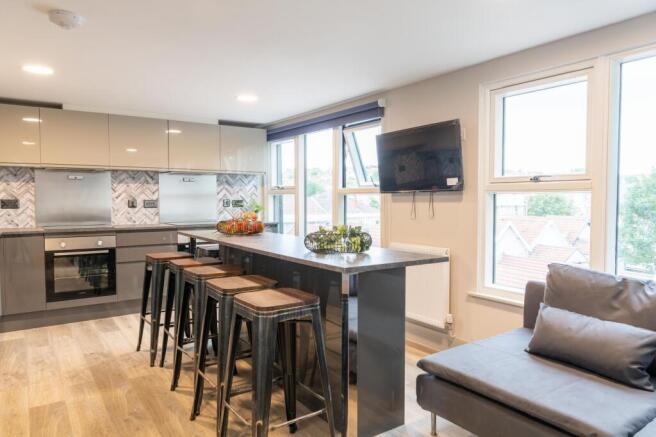 Modern open-plan kitchen with a long breakfast ...