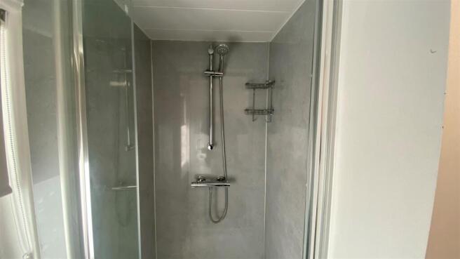 Modern tiled shower with glass door and fitting...