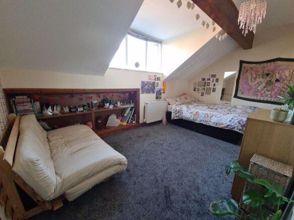 A spacious and inviting attic bedroom featuring...