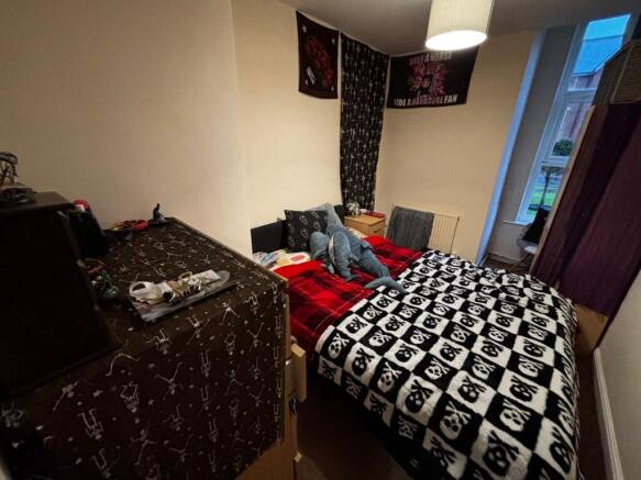 Cosy double bedroom with a patterned skull thro...
