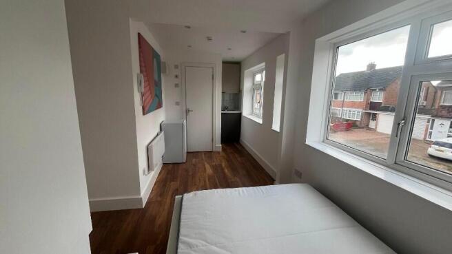 Bright, simply furnished bedroom with a large s...